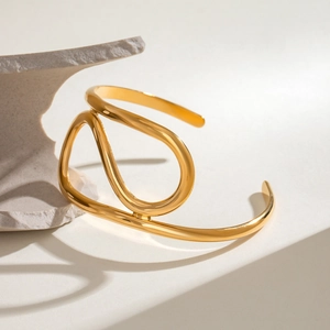 Polished gold irregular twisted line open bangle in minimalist stainless steel design