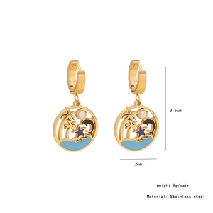 Detailed view of stainless steel gold earrings with palm tree and dolphin enamel pendants