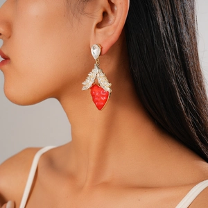 Detailed view of model wearing creative strawberry pendant earrings with rhinestones