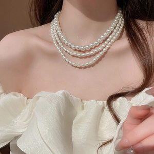 Close-up of elegant multi-layered white pearl necklace on model's neck for a vintage look