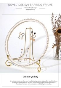 Detailed view of luxury gold jewelry display stand with lace and pearl accents