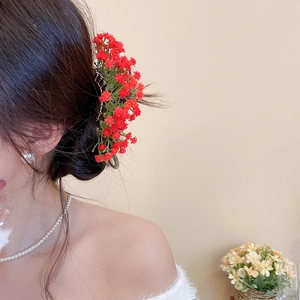 Detailed side view of a realistic red floral hair pin accessory in an elegant updo
