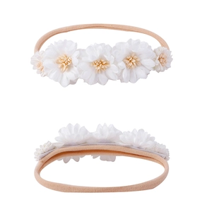 Detailed macro view of white floral infant headband with high elasticity beige cord