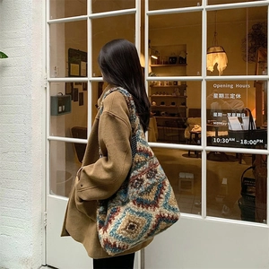 Detailed close-up of a large bohemian crochet tote bag with retro geometric patterns