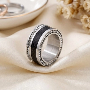 Detailed macro view of silver titanium steel ring with black carbon fiber and crystals