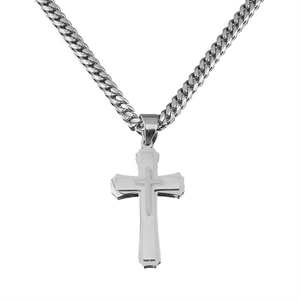Macro shot of silver dual-layer cross pendant with polished Cuban link chain