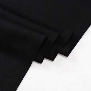 Close-up of black winter scarf fabric showing detailed twill texture and soft material