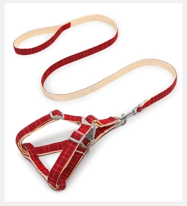Detailed view of the plaid fabric texture and sturdy plastic buckle on dog harness