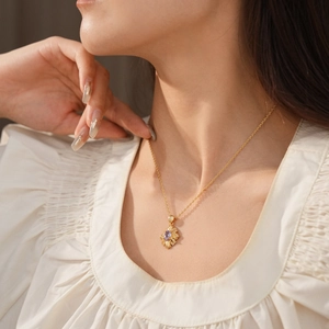 Detail of vintage gold necklace featuring a radiant purple gemstone pendant on a model neck