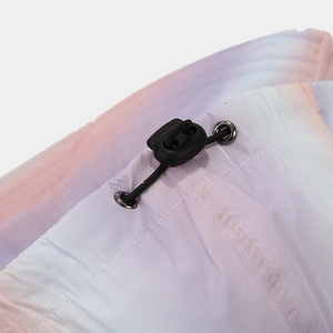 Detail of colorful tie-dye fabric with black drawstring toggle and metal eyelet fastener