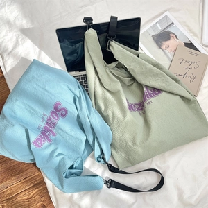 Détail de la texture gaufrée et du lettrage violet sur les sacs cabas décontractés