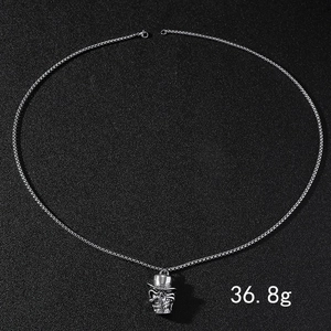 Détail d'un pendentif crâne argenté avec haut-de-forme sur chaîne de 36,8 g