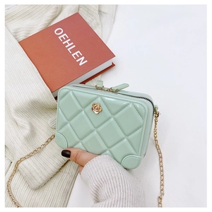 Detail view of mint green PVC jelly bag featuring diamond quilting and golden flower buckle