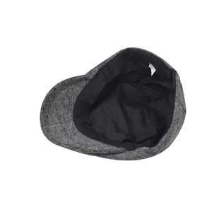 Detail view of grey herringbone newsboy cap with red stripes and soft inner lining