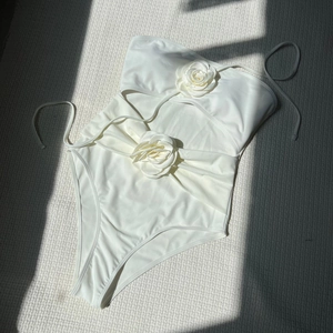 Detailed view of white cutout one-piece swimsuit with 3D handmade rose floral accents
