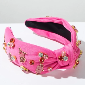Dettaglio fascia annodata rosa acceso con ciondoli Love e strass colorati