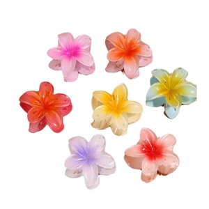 Vibrant plumeria flower hair claws in multiple colors including pink, yellow and blue