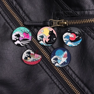 Detail of enamel wave pins and cat brooches on a black leather jacket texture