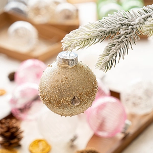 Golden glitter Christmas ball with beads on snow-covered pine branch decoration