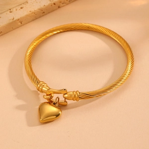 Titanium steel cable bracelet with gold heart pendant shown at a 45-degree angle