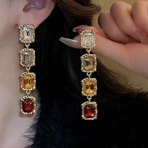 Elegant gold drop earrings with gradient square rhinestones in champagne and red tones