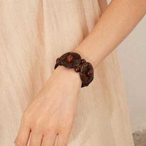 Close-up of vintage coconut shell and wooden bead stretch bracelet on woman's wrist