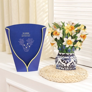 Detail of 3D pop-up greeting card featuring paper daffodils in a blue vase on windowsill