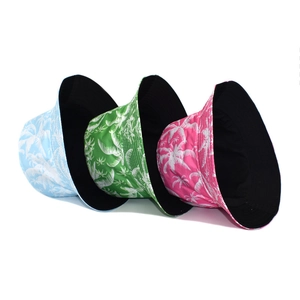 Three colorful reversible bucket hats with white palm tree prints for summer beach wear