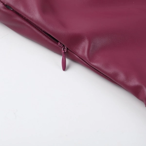 Détail macro de la texture en similicuir violet et de la couture du zip invisible