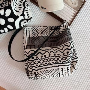 Detail view of linen tote bag with black and white geometric tribal patterns and leather straps