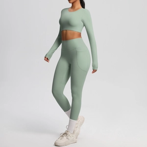 Detail view of high-waist yoga leggings with side pockets in breathable green fabric