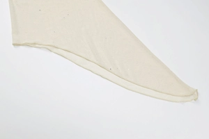 Nahaufnahme von beigem Netzstoff mit glitzernden Pailletten und feiner Kantennaht