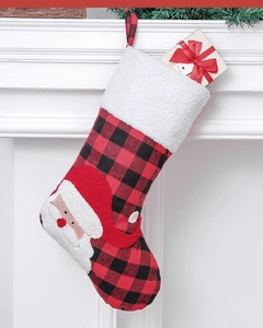 Detail of red and black buffalo plaid Christmas stocking with Santa patch and gift box