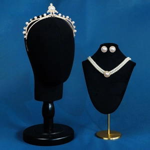 Detailed bridal jewelry set with pearl necklace, crystal tiara, and earrings on display