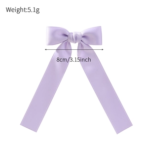 Light purple ribbon bow hair clip with long streamers on a white background