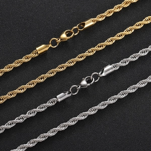 Macro detail of twisted gold and silver stainless steel chains with lobster clasps