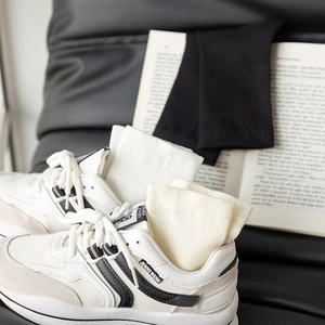 White cotton crew socks for women styled inside sporty leather sneakers with black accents