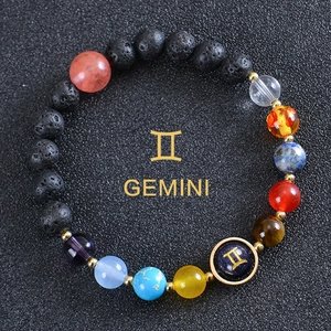 Macro detail of Gemini galaxy bracelet with black lava rock and colored gemstones