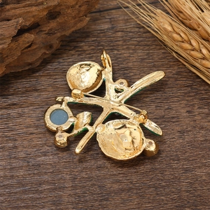 Golden starfish brooch with green enamel and blue gemstone on a rustic wooden surface