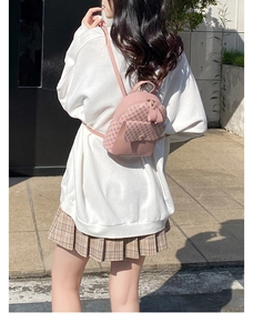 Close-up of pink printed mini backpack with metal zipper details and street style look