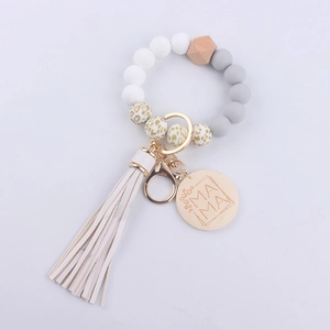 Detail of beaded keychain with leopard silicone beads, white tassel and MAMA engraved disc