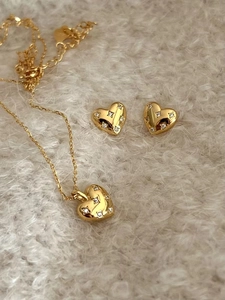 Vue détaillée du collier et des boucles d'oreilles cœur en or avec détails en zircons