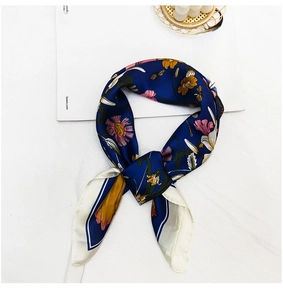 Detailed view of dark indigo silk scarf with floral daisy patterns and contrast border