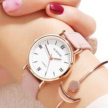 Close-up of pink leather watch with Roman numeral dial and rose gold moon bracelet