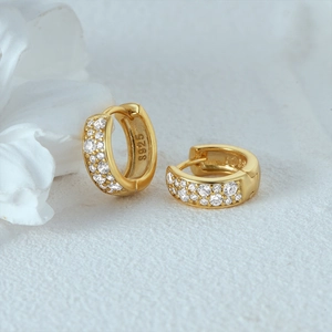 Close-up of S925 sterling silver stamp on a gold geometric hoop earring with zircon