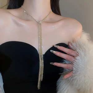 Dettaglio della collana dorata a strati con nappa e strass lucidi per donna elegante