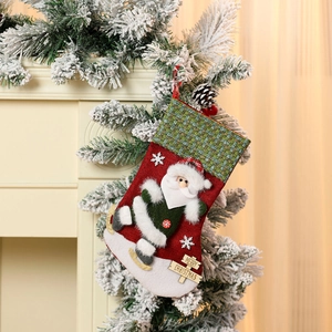 Close-up of a large velvet 3D Santa stocking hanging on a decorated fireplace mantel