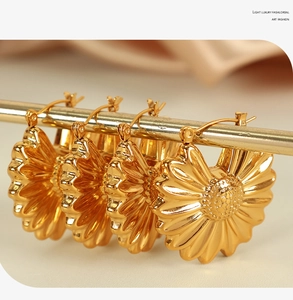 Macro shot of 18K gold plated hollow sunflower petal hoop earrings on a metal display rod