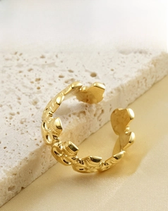 Détail d'une bague en acier inoxydable plaqué or 18k sur soie élégante et pierre blanche