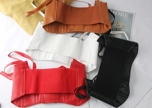 Flat lay of four elastic corset belts in red, black, white, and brown faux leather